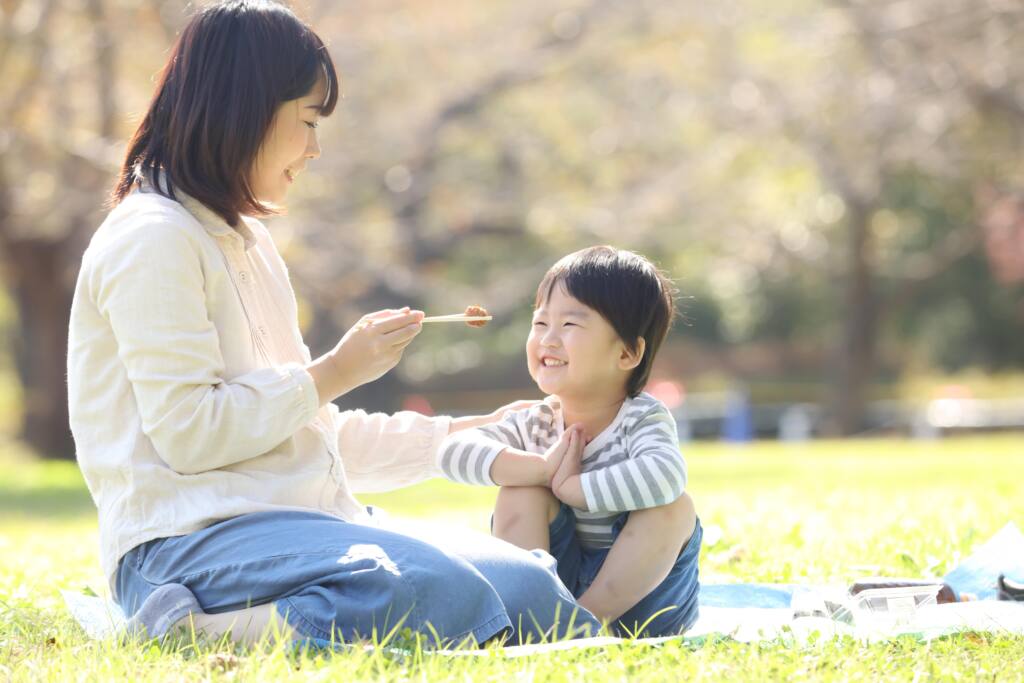 お母さんが子供に食べさせてあげている写真